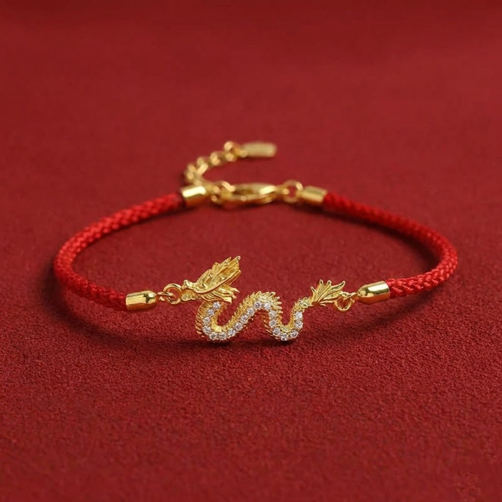 Gold bracelet with dragon design on a red cord against a red background