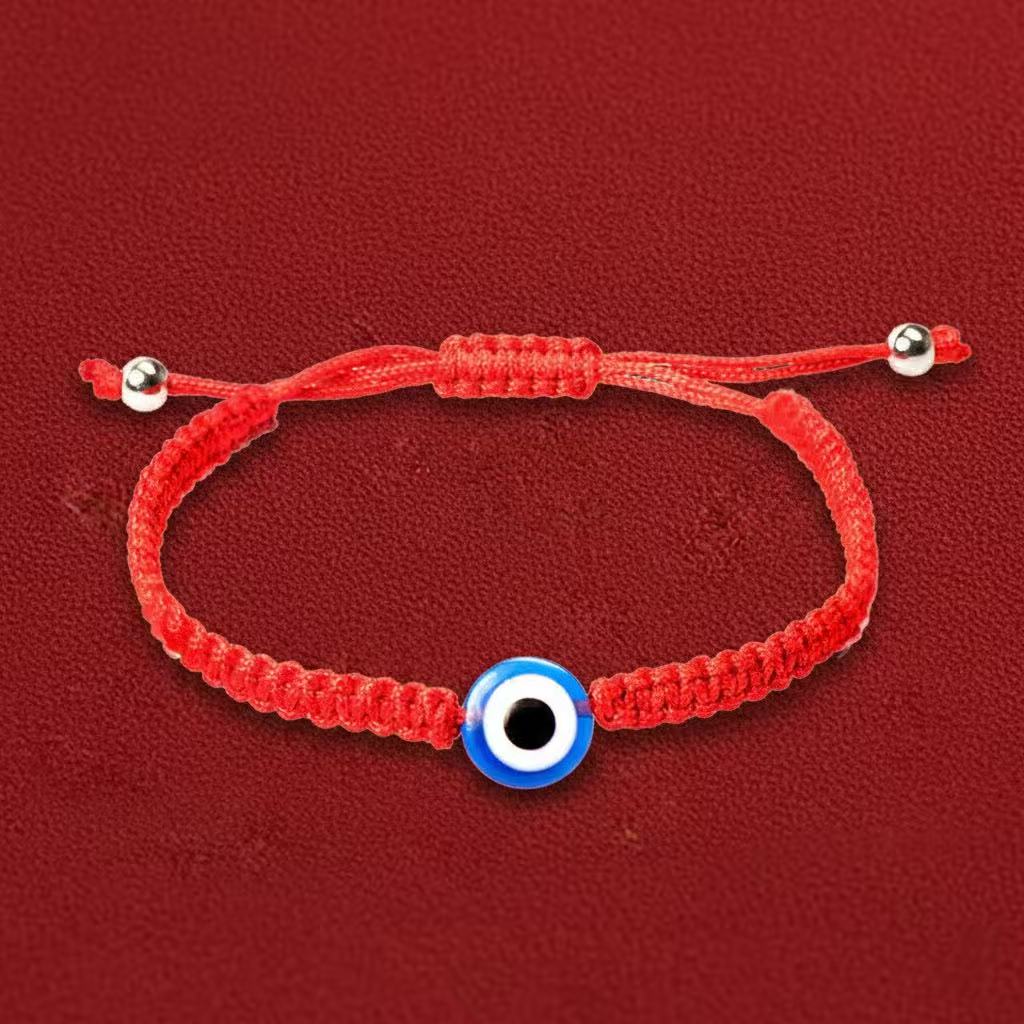 Red bracelet with a blue and white evil eye charm on a red background