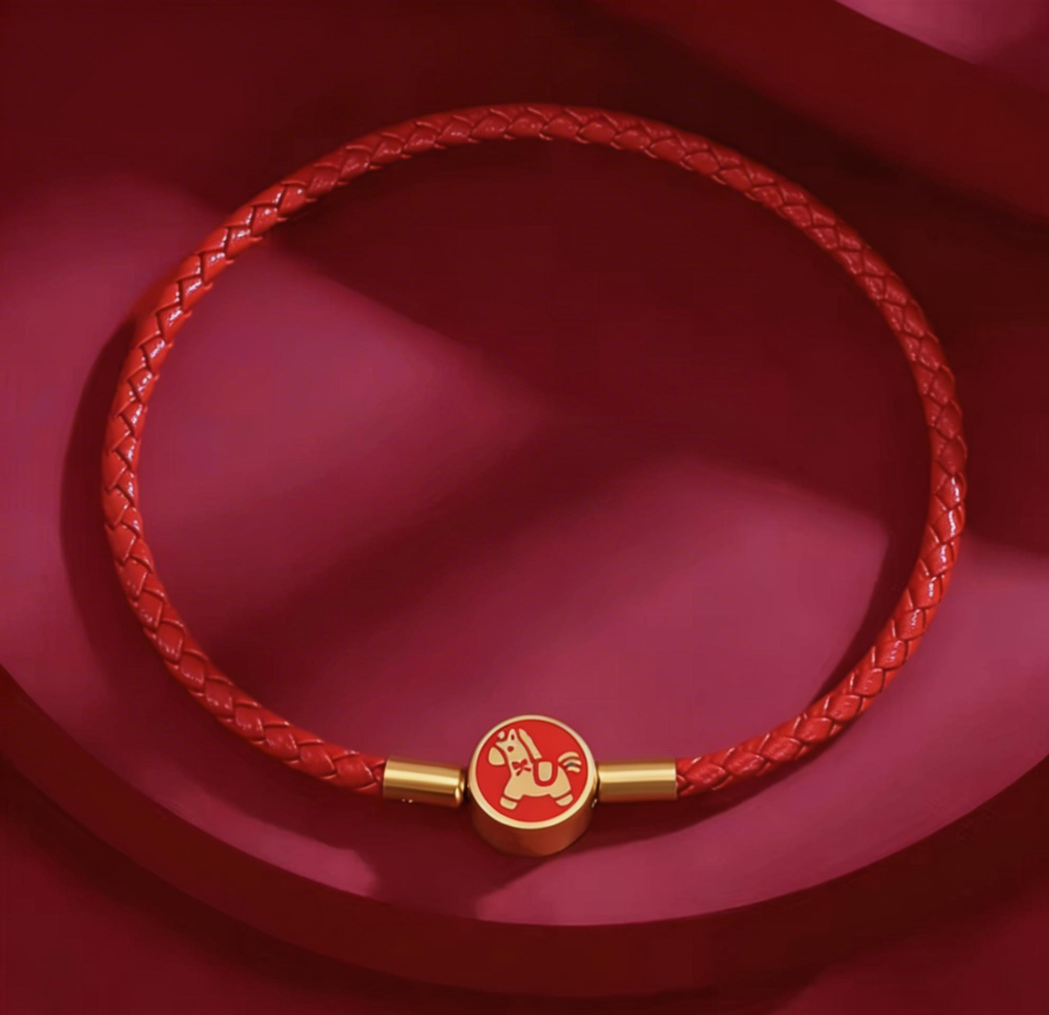 Red braided bracelet with a gold clasp on a red background