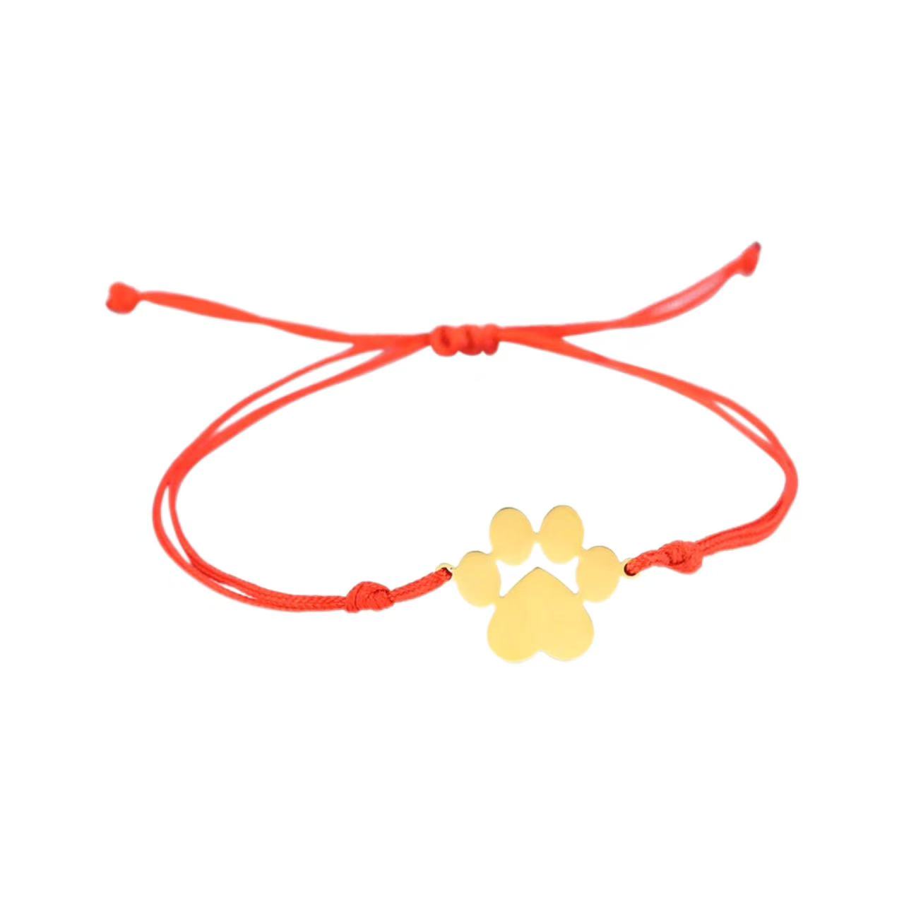 Red bracelet with a yellow paw-shaped charm on a white background