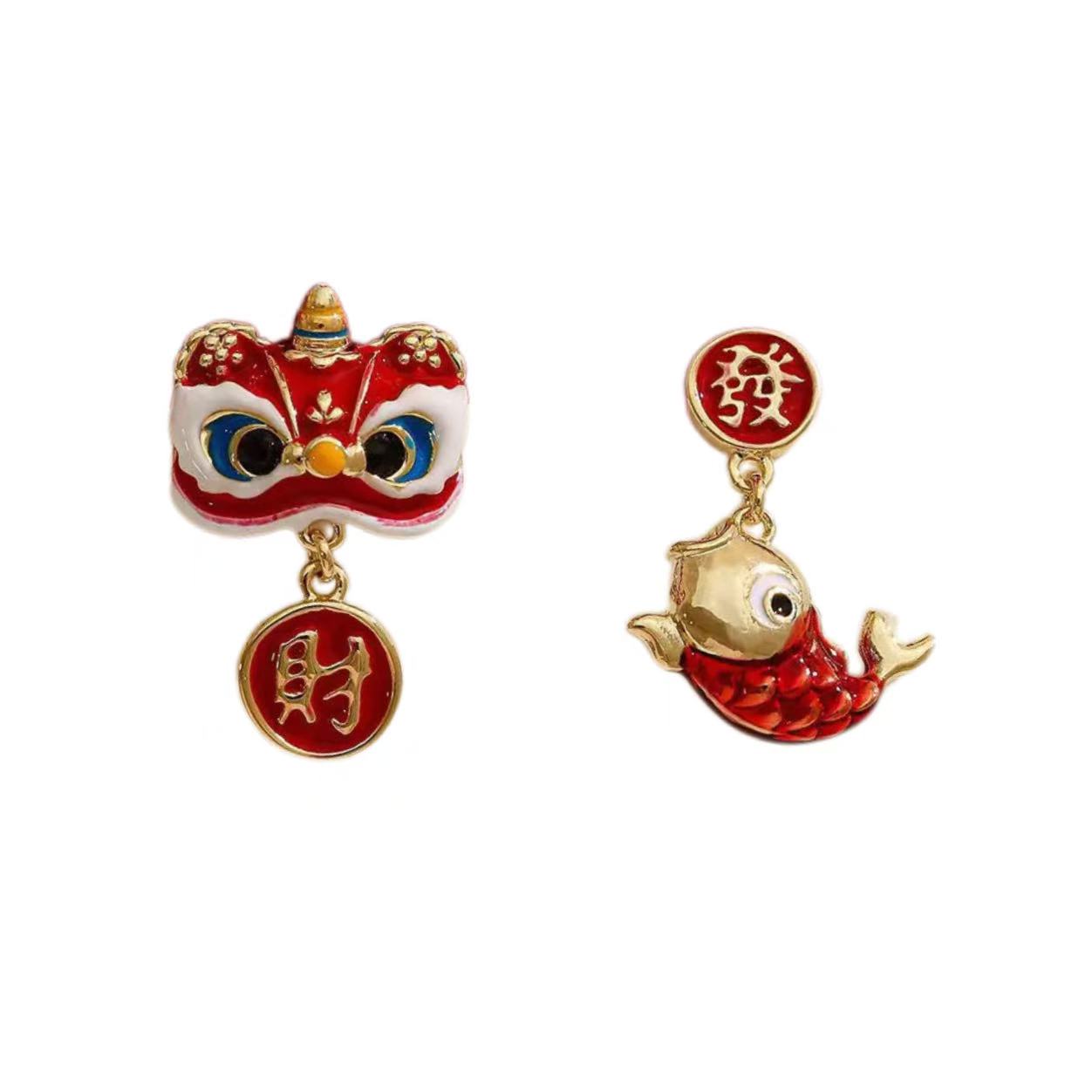 Pair of earrings with red and gold designs on a white background