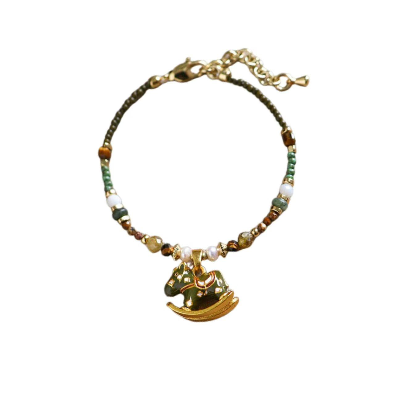 Bracelet with green beads and a gold anchor charm on a white background