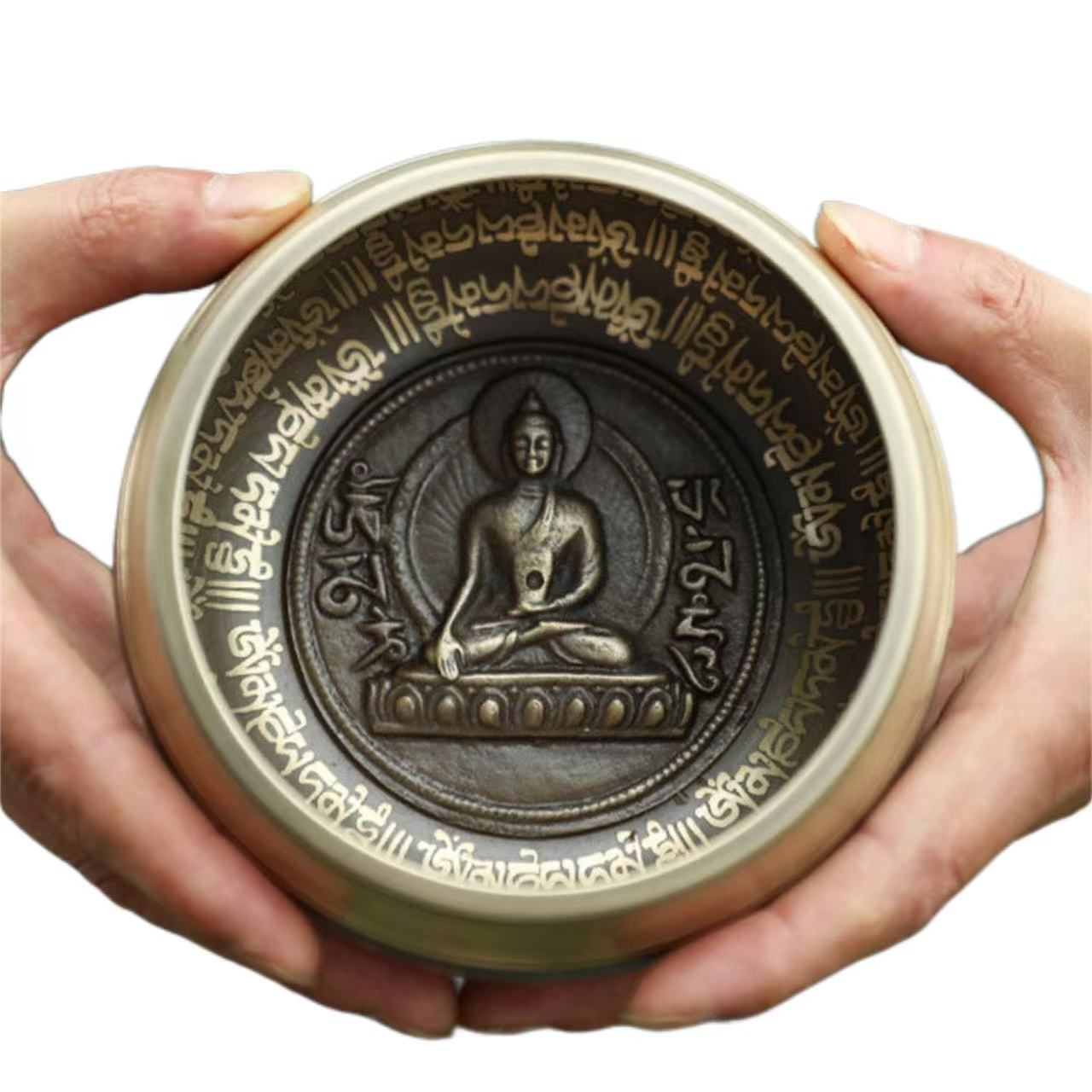 Circular object with Buddha illustration and text held by hands on a white background