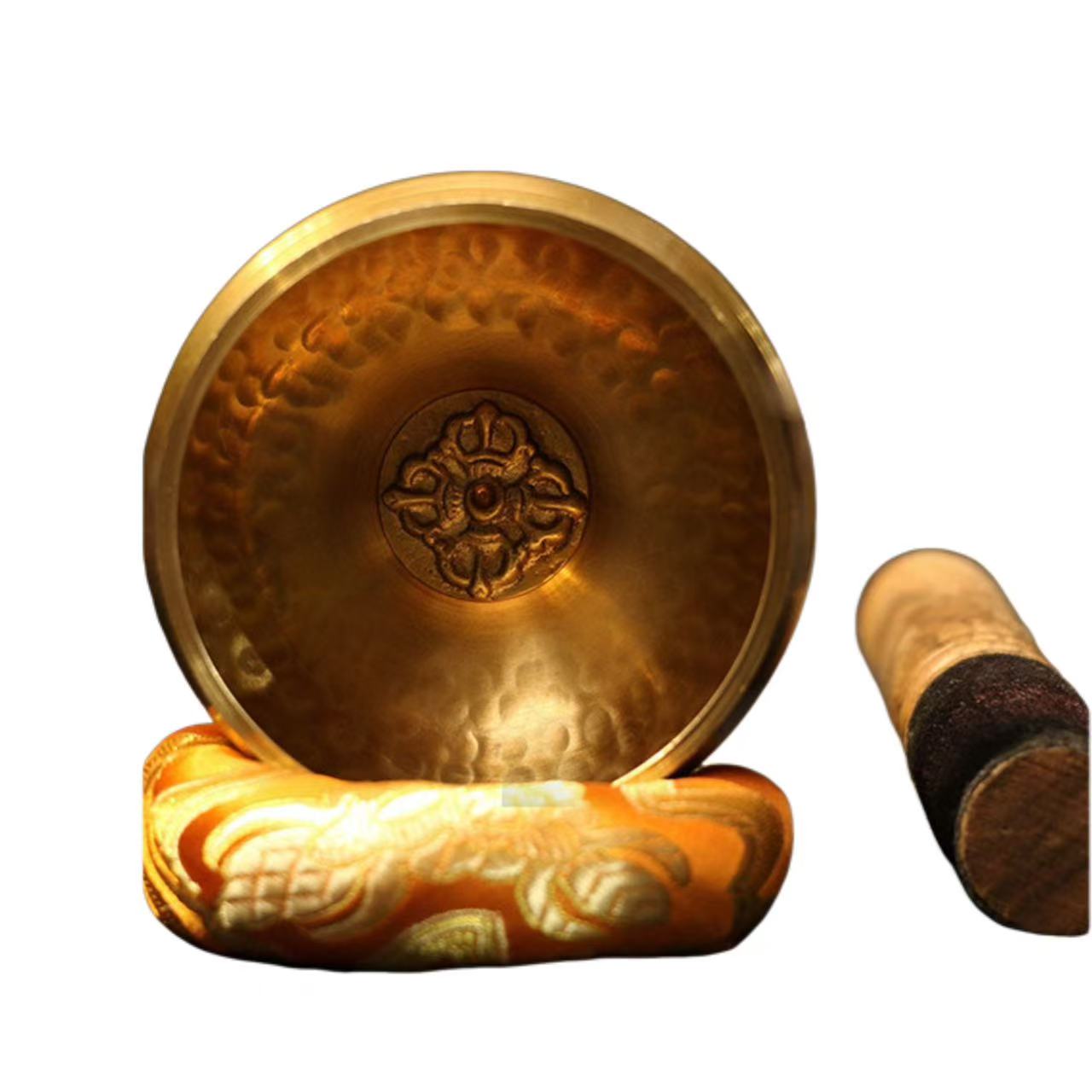 Brass singing bowl with decorative base and wooden mallet on a white background