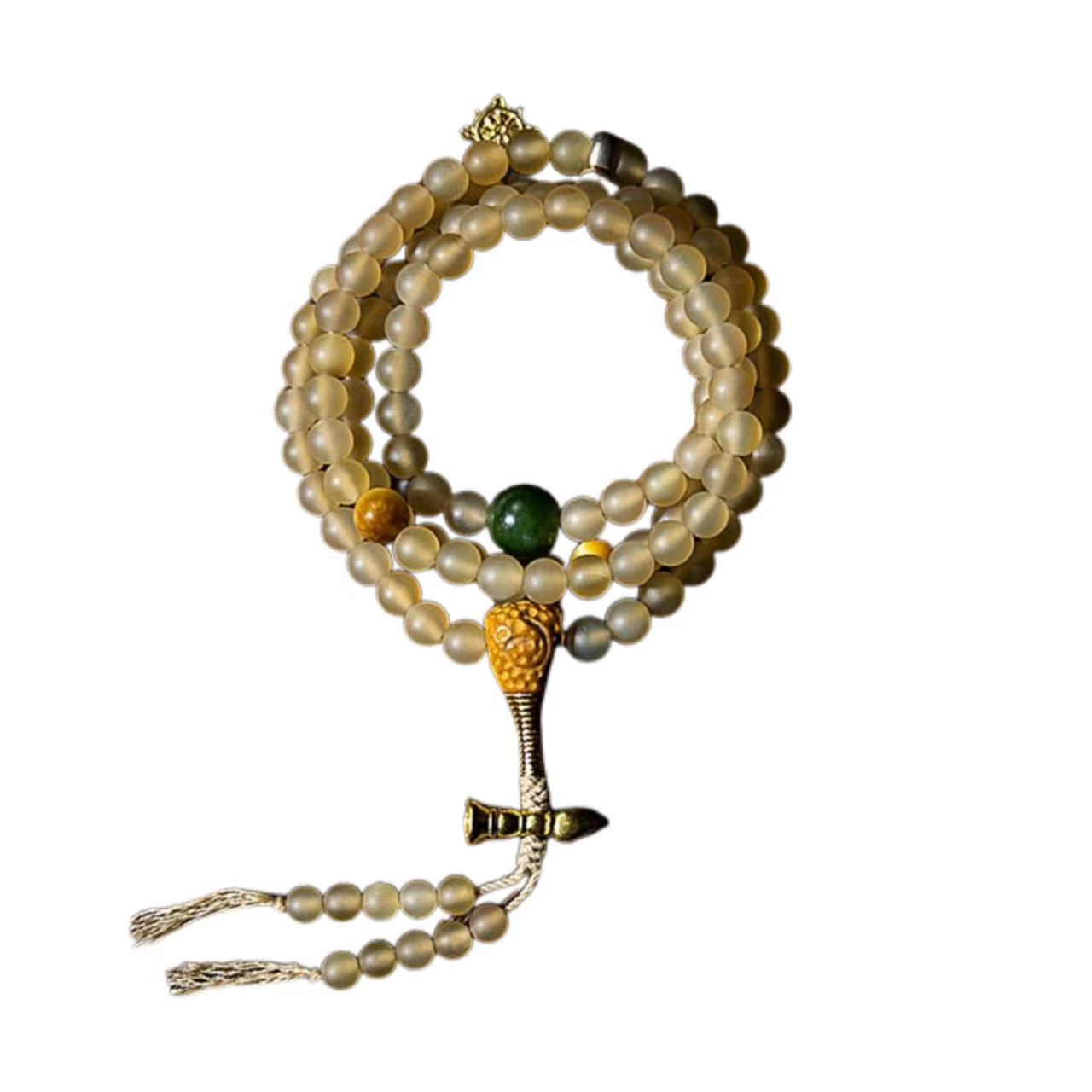 Beaded bracelet with a green stone and gold clasp on a white background