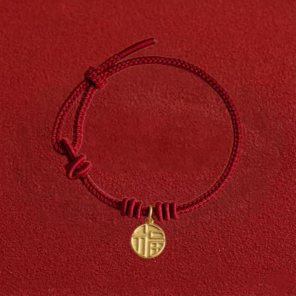 Red bracelet with a gold charm on a red background