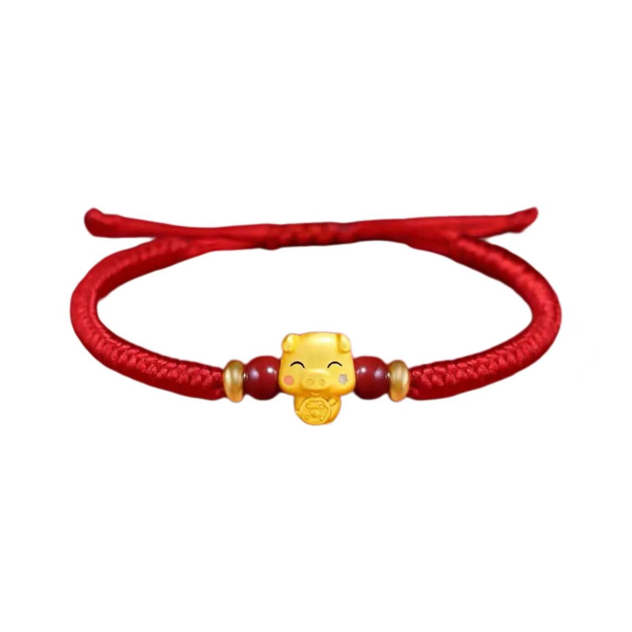 Red bracelet with a gold charm on a white background
