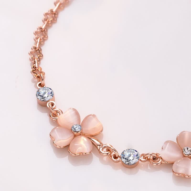 Crafted with rose gold-plated chain featuring three cherry blossom pink cat's eye clover flowers, each accented with sparkling crystal centers and star-shaped links, this bracelet exudes soft romance and symbolizes luck, hope, and love—perfect for gifting or personal wear.
