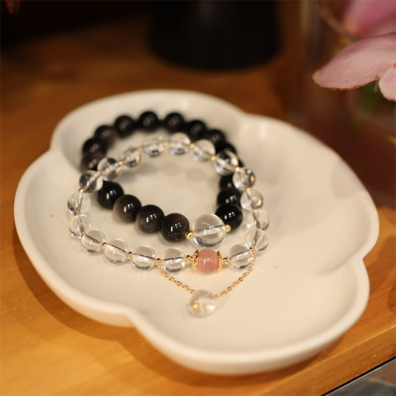 Two beaded bracelets on a white dish with a blurred background