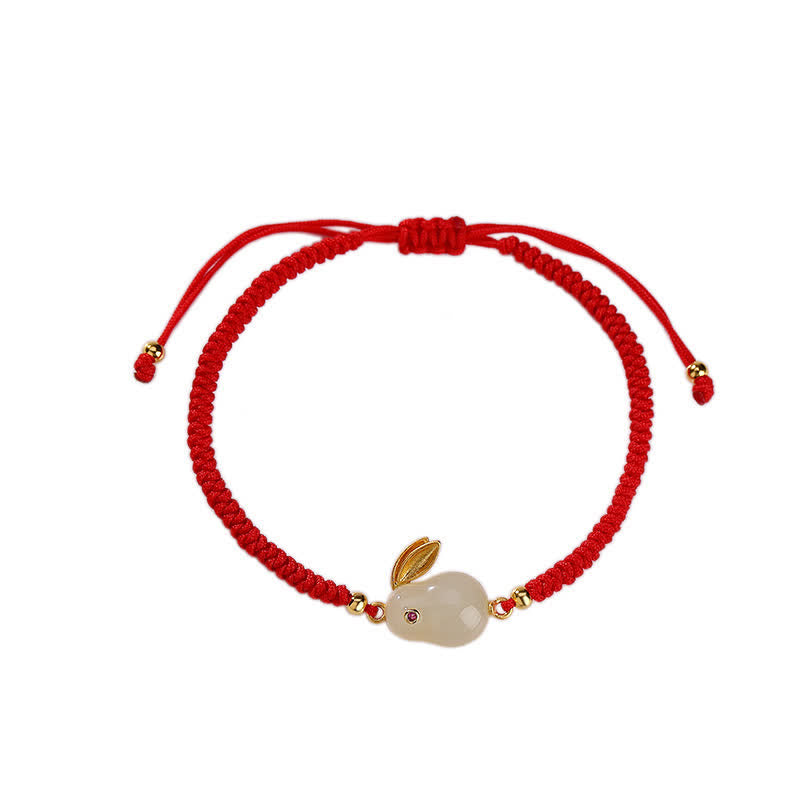 Red string bracelet with a small stone charm on a white background