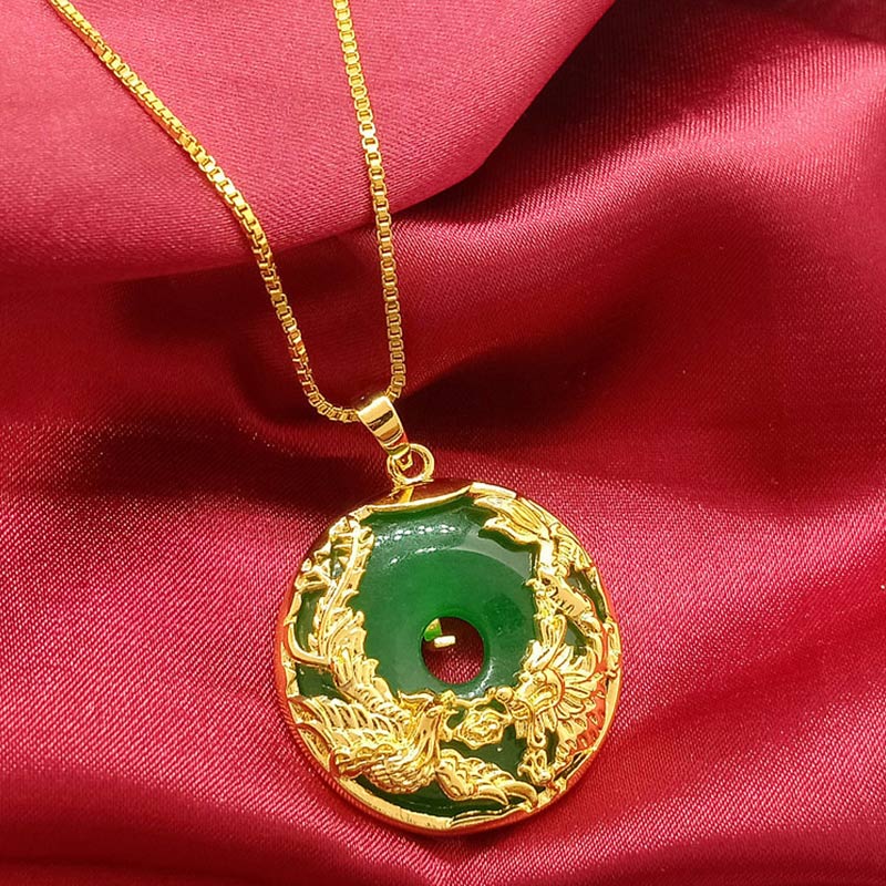 Gold necklace with a green pendant on a red fabric background