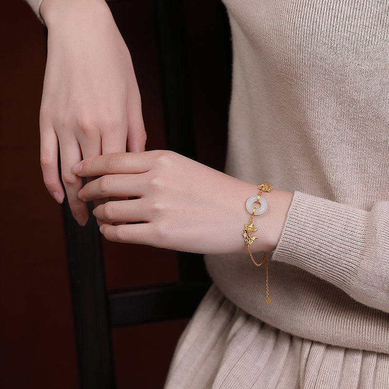 Close-up of a person wearing a gold bracelet with a moon design on a dark background