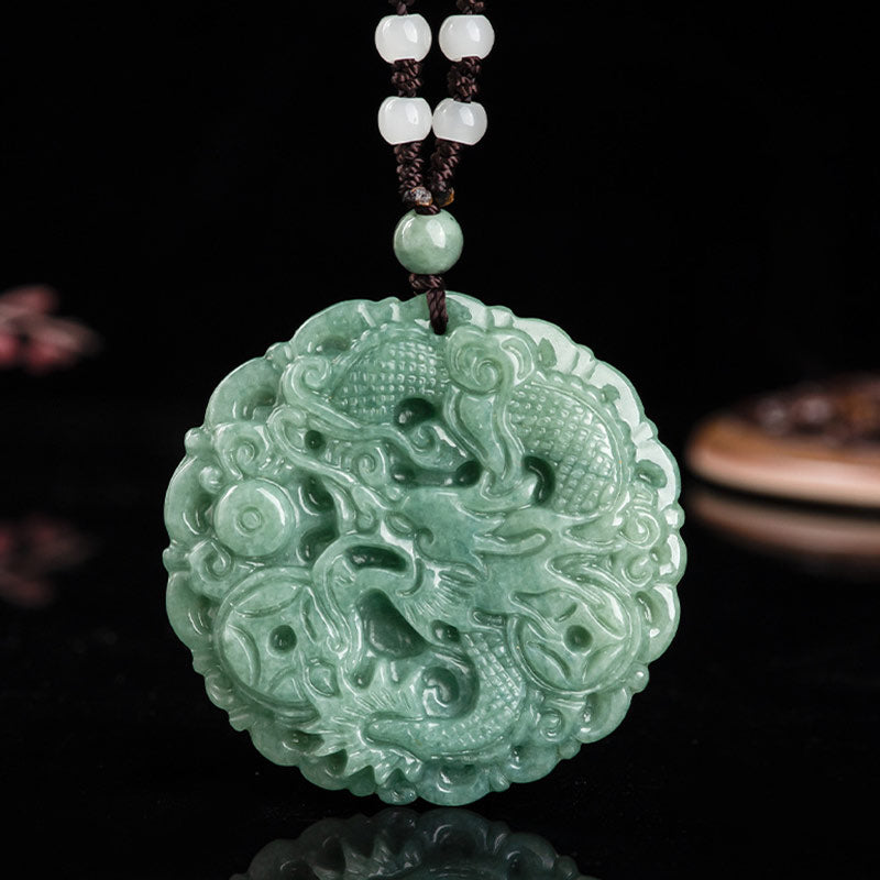 Green jade pendant with intricate dragon design on a dark background