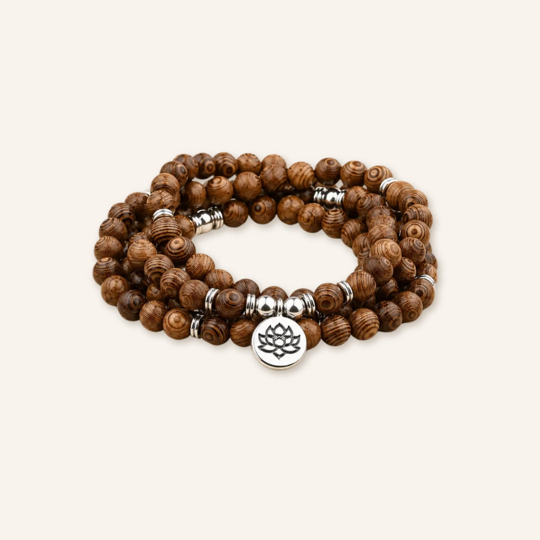 Clean Renewal Lotus Wood Mala Bracelet featuring deep brown wood beads, silver-tone spacer beads, and a lotus charm in a clean product image.