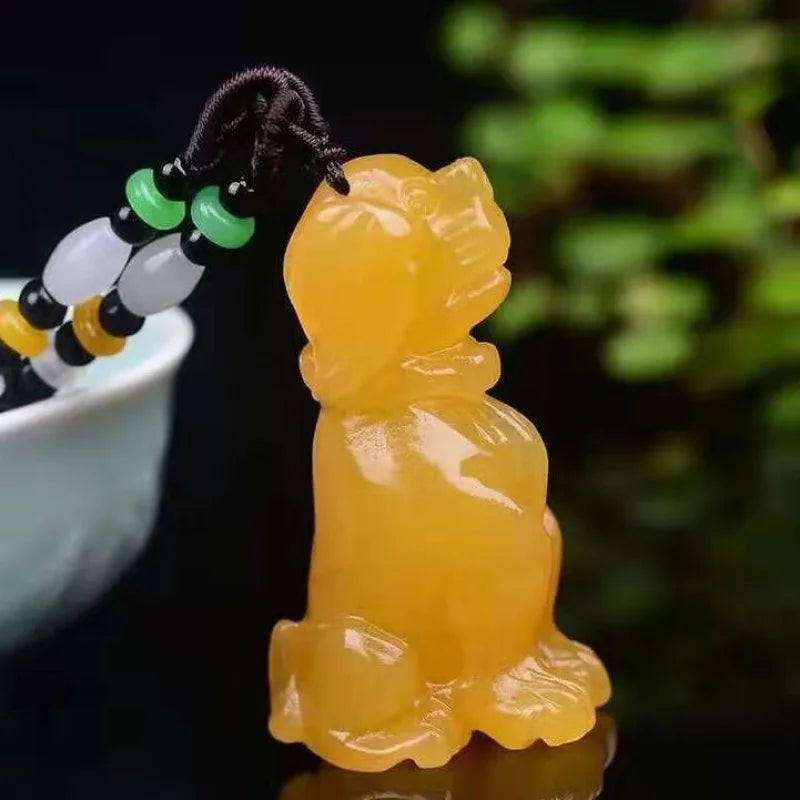 Yellow jade pendant resembling a traditional figure on a dark background