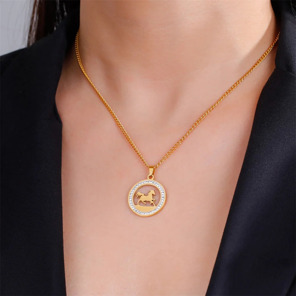 Gold necklace with a horse pendant on a person wearing a black outfit.