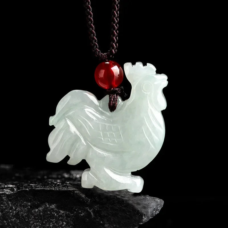 White rooster-shaped pendant with a red gemstone on a dark background