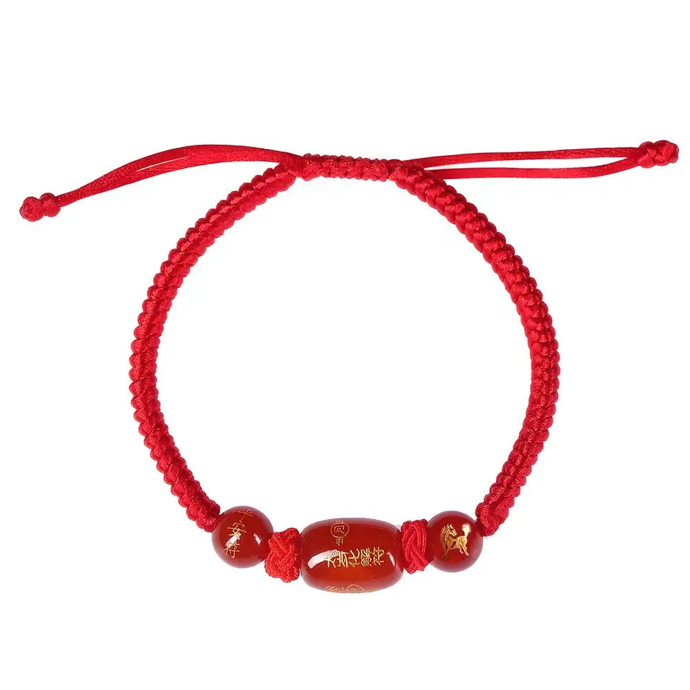 Red bracelet with three beads on a white background