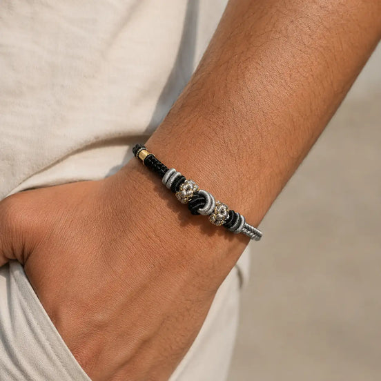 Black braided cord bracelet worn on the wrist