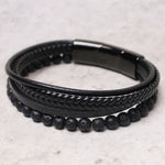 Top view of TheFuMaster black lava rock leather bracelet with braided details
