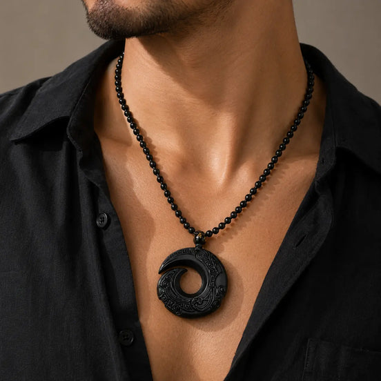 Black obsidian spiral pendant necklace worn on the neck