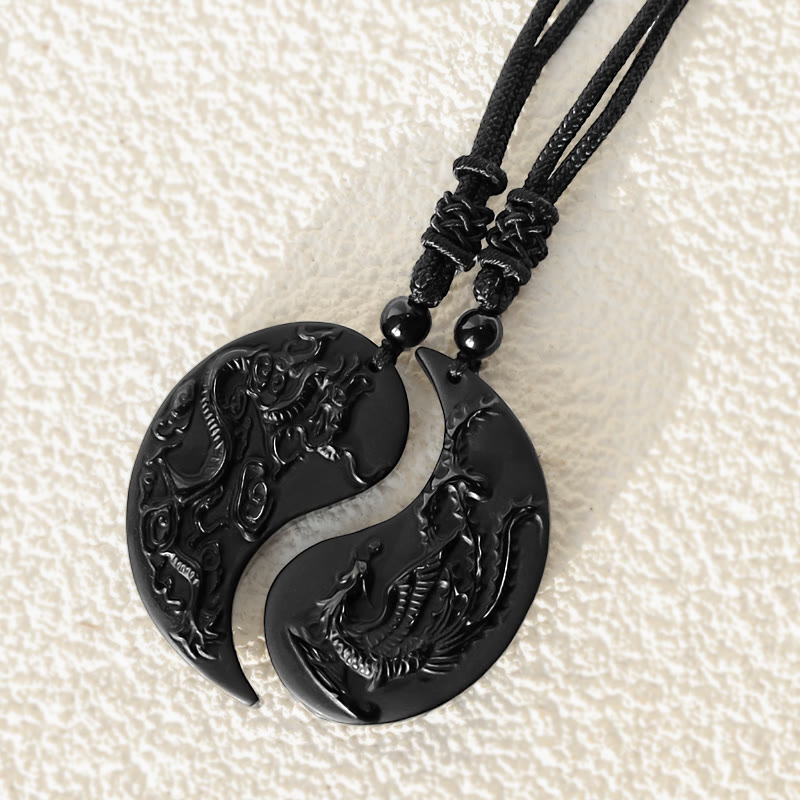 Close-up of Bound Together Dragon Phoenix Obsidian Couple Pendants with intricate yin yang design