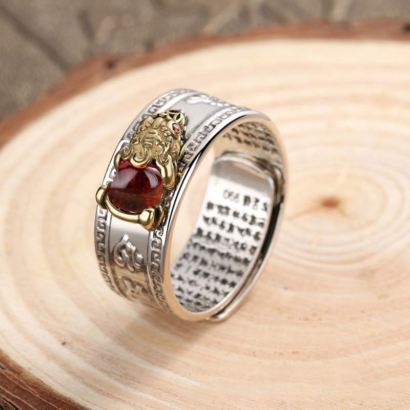 Decorative ring with a red gemstone on a wooden surface