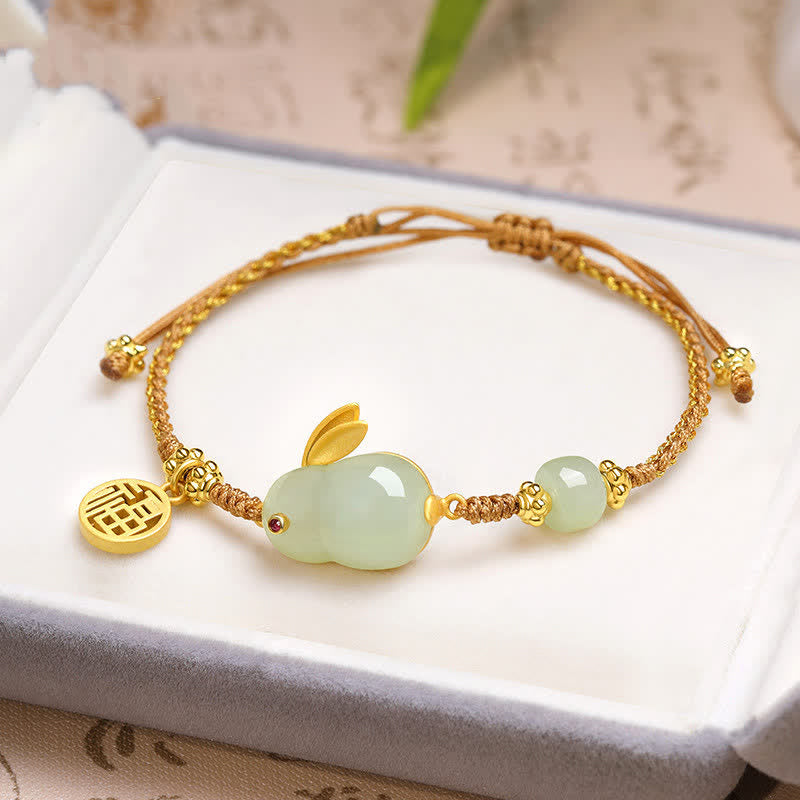 Bracelet with green bead and gold accents on a white surface