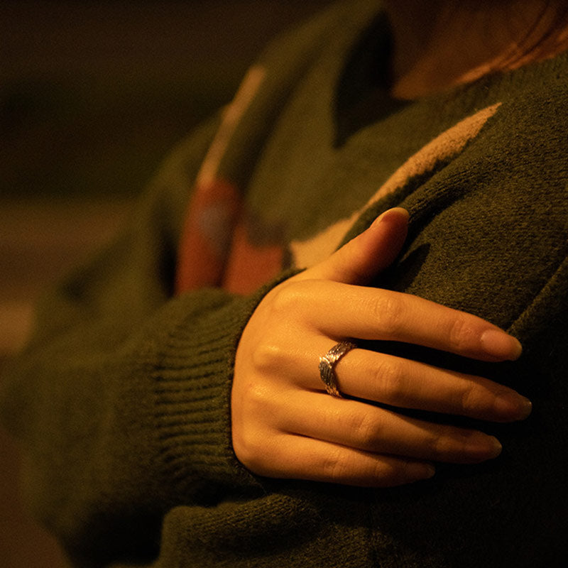 Feathered Guard Carved Wing Statement Ring worn on hand under warm light
