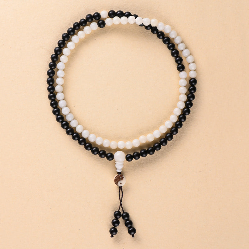 Necklace with black and white beads on a beige background