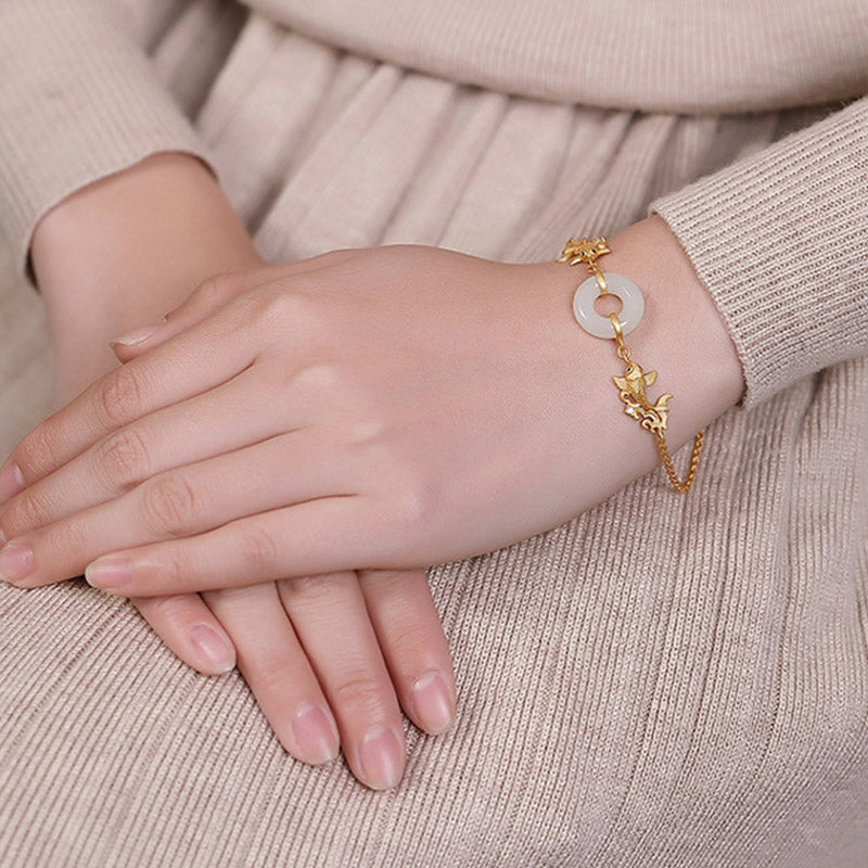Gold bracelet on a person's wrist with a neutral background