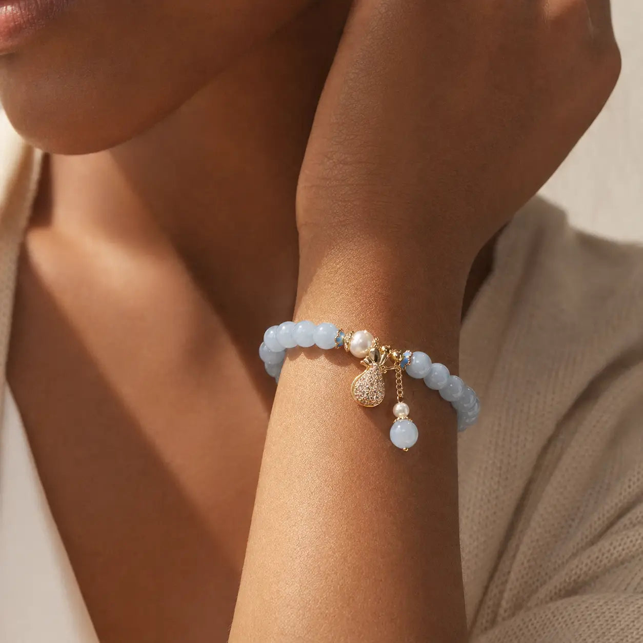 Quiet Fortune Fu Dai Pearl Blue Stone Bracelet worn on wrist with pearl and heart charm