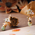 Side view of gray tridacna stone flower earrings with light green pearl drops – TheFuMaster
