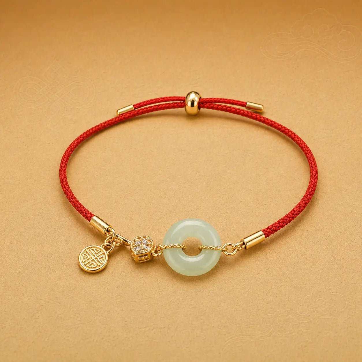Bracelet with gold accents and a red cord on a beige background