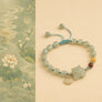 Decorative bracelet with a turtle charm on a beige background with floral design