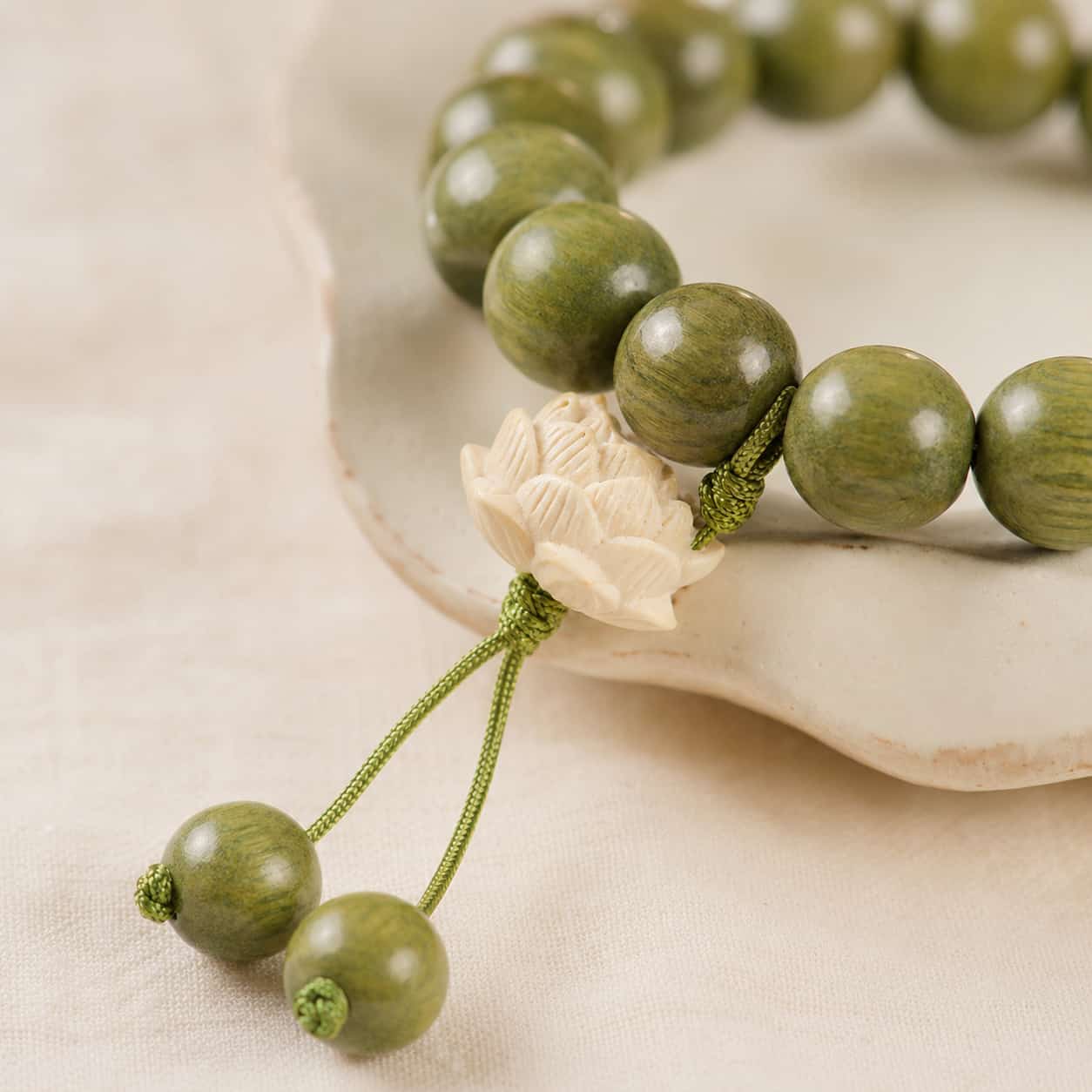 Lotus Green Wood Bead Bracelet shown from another angle with lotus