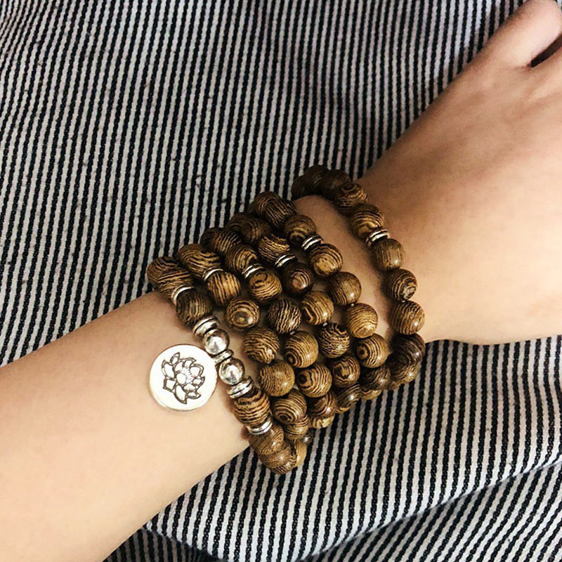 Grounded Forest Lotus Wood Bead Mala Bracelet worn on wrist with wood beads and lotus charm