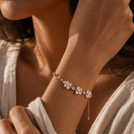 Pink petal charm bracelet worn on the wrist