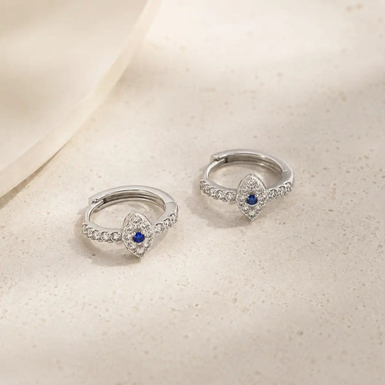 Silver evil eye huggie earrings detail view