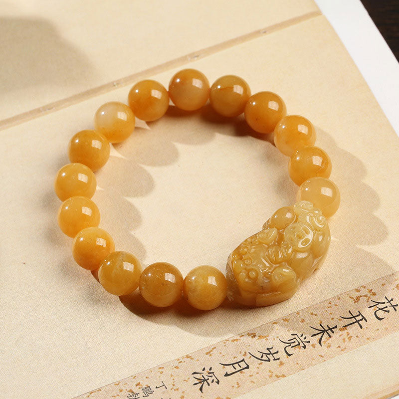 Golden silk jade PiXiu bracelet on beige fabric background – TheFuMaster
