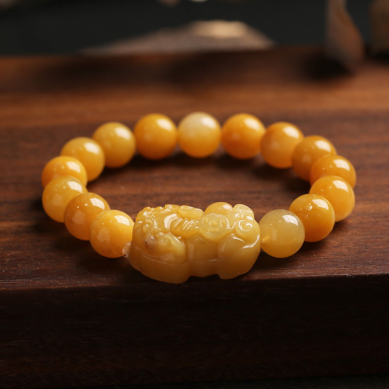 Golden jade PiXiu wealth bracelet displayed on wooden table – TheFuMaster
