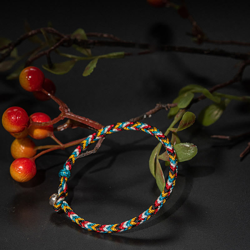 Lifestyle display of TheFuMaster Five-Color Protection Bracelet among natural branches and warm lighting.
