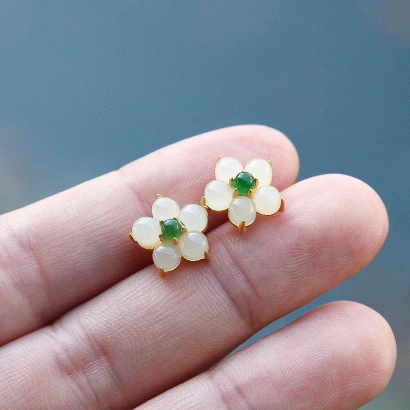 Close-up of White Jade Flower Stud Earrings held in hand showing smooth jade texture | TheFuMaster