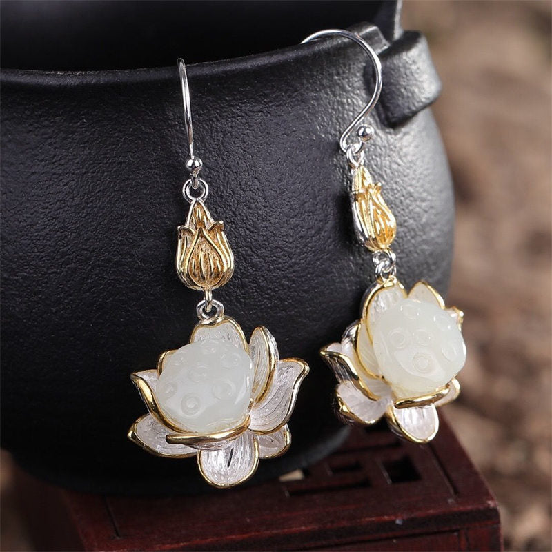 Close-up view of White Jade Lotus Drop Earrings featuring gold-plated lotus bud detail and natural jade texture