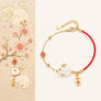 Bracelet with rabbit charms on a decorative card with floral and rabbit illustrations.