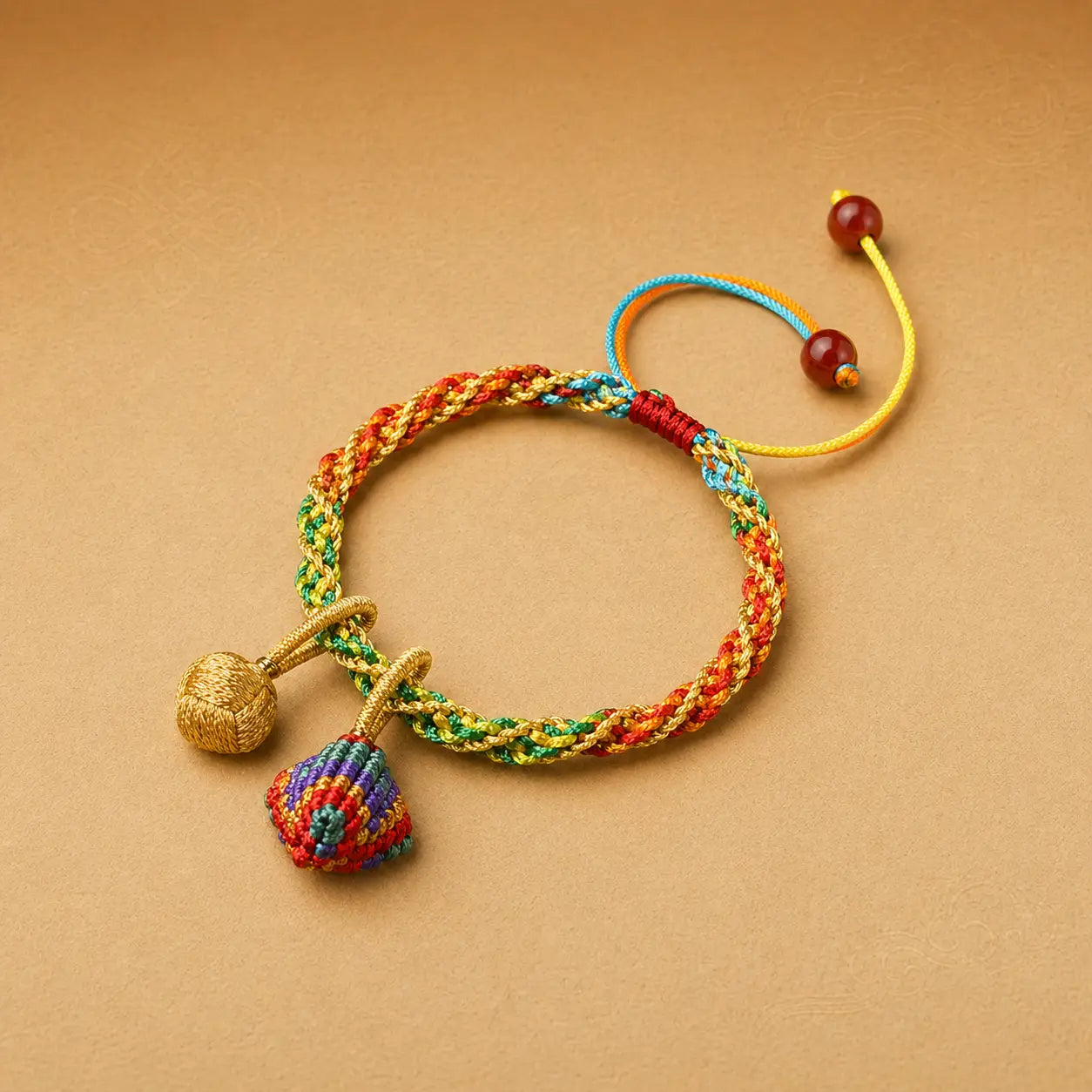 Colorful braided bracelet with decorative beads on a beige background