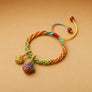 Colorful braided bracelet with decorative beads on a beige background